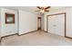 Carpeted bedroom with ceiling fan and wood trim around doorways and window at 8004 Lafayette Rd, Indianapolis, IN 46278
