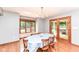Bright dining room featuring natural light, wood floors, views to green backyard, and door to patio at 8004 Lafayette Rd, Indianapolis, IN 46278