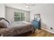 Bedroom with wood-look floors, a ceiling fan, and a window with green backyard views at 8126 Kilborn Way, Avon, IN 46123
