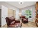 Comfortable living room featuring wood floors and two leather recliners next to a window at 8126 Kilborn Way, Avon, IN 46123