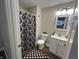 Well-lit bathroom featuring modern fixtures, a sleek vanity, and a stylish black and white shower curtain at 8277 N Waterford Dr, Columbus, IN 47201