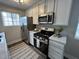 Modern kitchen features white cabinets, stainless steel appliances, granite countertops, and stylish lighting at 8277 N Waterford Dr, Columbus, IN 47201