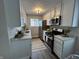 Modern kitchen features white cabinets, stainless steel appliances, granite countertops, and stylish lighting at 8277 N Waterford Dr, Columbus, IN 47201