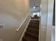 Staircase featuring neutral walls, handrail and view into the sun-drenched living room at 8277 N Waterford Dr, Columbus, IN 47201