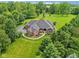 A lovely aerial view showing a well-maintained lawn, a circular driveway, and professional landscaping at 8301 Cooper Ln, Zionsville, IN 46077