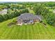 Expansive backyard with manicured lawn, mature landscaping, hot tub, pergola, and a paved driveway at 8301 Cooper Ln, Zionsville, IN 46077