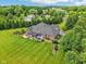 Aerial view of backyard with a hot tub on the back patio, pergola, manicured lawn and mature landscaping at 8301 Cooper Ln, Zionsville, IN 46077