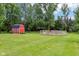 A red barn and a wooden fence in a large, well-maintained backyard, providing ample space and rustic charm at 8301 Cooper Ln, Zionsville, IN 46077