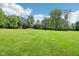 Expansive green backyard features a red barn and an open pasture area surrounded by mature trees at 8301 Cooper Ln, Zionsville, IN 46077