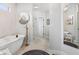 Bright and airy bathroom featuring a soaking tub, neutral tile, and modern fixtures at 8301 Cooper Ln, Zionsville, IN 46077