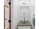 Powder room featuring a glass bowl sink, framed mirror, and modern lighting fixtures at 8301 Cooper Ln, Zionsville, IN 46077
