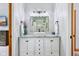 Bathroom featuring a granite vanity, modern lighting fixtures, and white cabinetry at 8301 Cooper Ln, Zionsville, IN 46077
