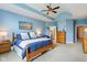 Comfortable bedroom with a blue color scheme, a ceiling fan, and wooden furniture at 8301 Cooper Ln, Zionsville, IN 46077