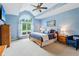Inviting bedroom with a large window, blue walls, ceiling fan, and carpet flooring at 8301 Cooper Ln, Zionsville, IN 46077