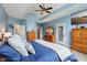 Spacious bedroom showcasing wood furniture, white trim, a ceiling fan and multiple access doors at 8301 Cooper Ln, Zionsville, IN 46077