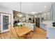 Dining area adjacent to kitchen with wood table, view into the living room, and hardwood floors at 8301 Cooper Ln, Zionsville, IN 46077