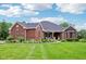 Charming brick home with covered porch, manicured lawn, and verdant landscaping on a sunny day at 8301 Cooper Ln, Zionsville, IN 46077