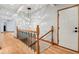 Bright hallway featuring hardwood floors, decorative lighting, and a stairway with ornate wrought iron railings at 8301 Cooper Ln, Zionsville, IN 46077
