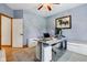 Home office with wood flooring, a grey desk, a horse picture on the wall, and a ceiling fan at 8301 Cooper Ln, Zionsville, IN 46077