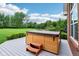 Outdoor hot tub on a deck with views of the landscaped backyard, surrounded by trees and shrubs at 8301 Cooper Ln, Zionsville, IN 46077