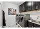 Laundry room with front-load washer and dryer, dark cabinets, and stylish patterned flooring at 8301 Cooper Ln, Zionsville, IN 46077