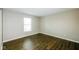 This bedroom offers beautiful dark wood-look floors, neutral walls, and a large window for natural lighting at 8310 Becks Mill Ln, Indianapolis, IN 46113