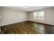 Bright living room with dark wood flooring, neutral-toned walls, and ample natural light from large windows at 8310 Becks Mill Ln, Indianapolis, IN 46113
