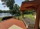 Beautiful backyard view of the lake with a swing on the deck, surrounded by lush greenery and a blue sky at 8664 S Nash Dr, Nineveh, IN 46164