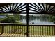 The balcony overlooks a calm lake and lush greenery, with a uniquely decorated gable at 8664 S Nash Dr, Nineveh, IN 46164