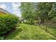 Well-maintained backyard with green lawn, trimmed bushes, fenced in yard, and some trees for shade at 8753 Champions Dr, Indianapolis, IN 46256