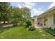 Green backyard with grass and various landscaping, a deck with chairs, and a partial view of the home at 8753 Champions Dr, Indianapolis, IN 46256