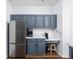 Kitchen area featuring blue cabinets, stainless steel appliances, and a white countertop at 8753 Champions Dr, Indianapolis, IN 46256