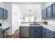 Bright kitchen featuring blue cabinets, stainless steel appliances, and an open concept design at 8753 Champions Dr, Indianapolis, IN 46256