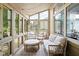 Inviting sun room with modern furniture, large windows with backyard views and decorative overhead lighting at 8753 Champions Dr, Indianapolis, IN 46256