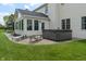 Well-manicured backyard featuring a patio with a hot tub, seating, and sunroom addition at 8904 Carnation Dr, Noblesville, IN 46060