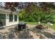 Cozy backyard patio with a stone fire pit and outdoor dining set on a well-maintained lawn at 8904 Carnation Dr, Noblesville, IN 46060
