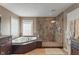 Modern bathroom with tile floors, large tub, glass-enclosed shower, and double vanity at 8904 Carnation Dr, Noblesville, IN 46060