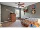 This is a nicely decorated bedroom with a ceiling fan, a window, and GABE spelled out on the wall at 8904 Carnation Dr, Noblesville, IN 46060