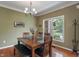 Dining room featuring hardwood floors, modern chandelier, and a view of the well-kept lawn at 8904 Carnation Dr, Noblesville, IN 46060