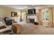 Spacious living room with plush carpeting, a cozy fireplace, and plenty of natural light from large windows at 8904 Carnation Dr, Noblesville, IN 46060
