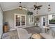 Well-lit sunroom boasts a ceiling fan, tile floors, neutral decor, and sliding glass doors to bring the outside in at 8904 Carnation Dr, Noblesville, IN 46060