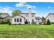 Large backyard view of home with patio and well-manicured lawn at 9653 Cypress Way, Carmel, IN 46032