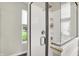 Stylish shower with clear glass enclosure featuring a shower head and convenient built-in shelving at 9653 Cypress Way, Carmel, IN 46032