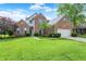 Beautiful brick home with manicured lawn, blue sky, and trimmed hedges at 9653 Cypress Way, Carmel, IN 46032