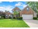 Beautiful brick home with manicured lawn, blue sky, and trimmed hedges at 9653 Cypress Way, Carmel, IN 46032