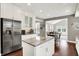 Bright kitchen featuring an island, stainless steel appliances, and hardwood floors flowing into the dining area at 9653 Cypress Way, Carmel, IN 46032