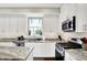 Bright kitchen featuring granite countertops, white cabinets, stainless appliances, and natural light from the window at 9653 Cypress Way, Carmel, IN 46032