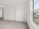 A bright bedroom with neutral carpeting and a view from the window at 10416 Crystal Coop Ln, Indianapolis, IN 46235