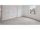 A bedroom with neutral carpeting, two doors, and a window providing natural light at 10416 Crystal Coop Ln, Indianapolis, IN 46235