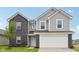Charming two-story home with gray siding, a black brick facade, and an attached two-car garage at 10416 Crystal Coop Ln, Indianapolis, IN 46235